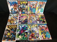 Full lot of 11 X-Men comic books displayed on black surface showing various titles including The Uncanny X-Men and X-Men