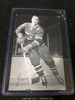 Full view of the black and white photo of Jean Beliveau in Montreal Canadiens uniform, showing the autograph and visible creases.