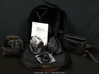 Front view of Sony digital video camera recorder with accessories including manual, batteries, cables, detachable lens, and carrying cases.