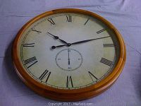 Front view of the oak mantel clock showing the clock face with Roman numerals and oak frame.