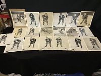 Seventeen vintage black and white photos of 1950s Toronto Maple Leafs hockey players arranged on a dark surface. Photos show players posing with hockey sticks in team uniform.