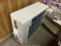 View of the exterior of the Fujitsu commercial air conditioner, showing the white casing and vented side panel.