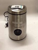 Front view of a Secura stainless steel electric coffee and spice grinder with power cord and control button.