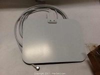 Two white ultra-thin indoor HDTV antennas with attached long coaxial cables shown together on a surface.