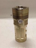 Two gold metallic Sky Ray Super Bright LED flashlights side-by-side, showing ribbed design and single power button each.