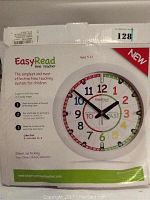 Photo showing the front of the boxed Easy Read Time Teacher Children's Wall Clock with instructional text and clock face visible.