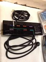 Close-up of Monster HDP 850G Power Center with coiled HDMI cable and audio/video cables, showing connection ports and cables details.