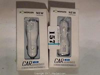 Two white USB car chargers in retail boxes side by side on a flat surface