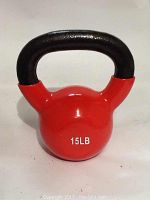 Close-up photo of a red 15LB kettlebell with rubber coating and black handle