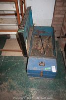 Wooden tool box open showing interior and some tools inside, placed on floor beside stairs