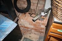 Stack of approximately 100 red clay bricks with various hand tools on top including levels and trowels.