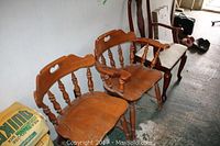 Two Windsor style wooden chairs with heart-shaped cutouts and curved backs showing wear, natural wood finish