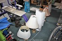 Photo showing two electric table lamps with brass bases and fabric shades, with Honeywell heater/air purifier behind.