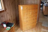 Front and angled view of tall faux wood dresser with 10 drawers, showing some surface wear and scratches.
