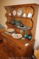 Overall view of Marius Ouellet solid wood hutch and buffet set with decorative plates and glassware displayed on hutch shelves and buffet surface.