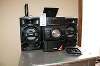 Full view of Sony stereo system with two speakers and additional frames on a table