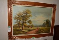Frontal view of the large framed oil painting depicting rural landscape with trees, a dirt path, and cabin.