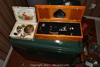 Overview of wooden jewel box with mirror open showing the costume jewelry displayed, next to two vintage compacts and a display box with small items.