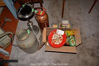 Lot contents showing Pyrene fire extinguisher, milk pail, ashtray, and box of cookie tins on carpeted floor