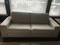 Front view of cream leather couch showing two seat cushions and block arms