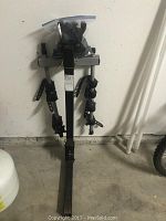 Full view of Thule hitch-mounted rack assembled, standing on garage floor