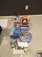 Wide angle view showing assorted board games including Scrabble, Chess, art supply box, toys, and inflatable balls arranged on floor