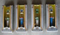 Front view of four gas pump replicas in yellow and white packaging showing the detailed miniature models.