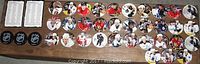 Photo showing 43 colorful hockey player pogs and 2 NHL puck shaped tokens arranged on a surface.