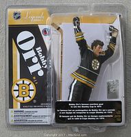 Front view of the unopened plastic blister pack containing the Bobby Orr figure in Boston Bruins uniform celebrating Stanley Cup goal.