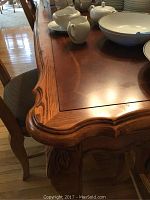 Corner close-up showing molded carved edge detail and wood inlay pattern on tabletop