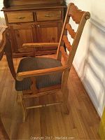 Side view of armchair showing ladder-back design, armrests, and houndstooth seat