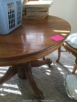 Top view of round wooden table surface showing wood grain and part of the edge with items placed on top.