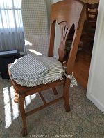 Wooden chair full view with striped cushion and floral seat board visible