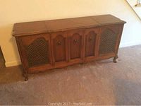 Front view of the brown Sears wooden turntable console with decorative mesh speaker covers and paneled doors.