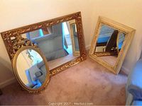 All three mirrors shown leaning against wall on carpet with a sectional sofa in background. Composition shows size differences and frame details.