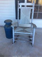 Front view of the wood rocking chair and blue milk jug