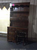 Photo of the dark brown wooden hutch and chair together showing overall condition and design