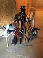 View of wheelchair, canes, crutches, bath benches, portable toilet, heating pads and scale arranged on floor