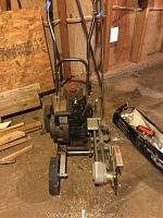 Full view of Craftsman gas powered edger showing metal frame, dual wheels, and engine mounted on platform