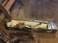 Cable puller tool inside long, rectangular cardboard box showing "Professional Quality" label.