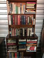 Full view of multiple shelves packed with various books, showing a mix of vintage and modern titles on music, history, and general coffee table books.