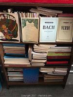 Overall shelf view showing multiple stacks of sheet music volumes and scores