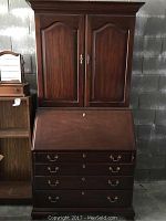 Full view of the two-piece secretary desk showing upper cabinet and lower bureau.