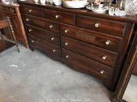 Full dresser front showing all drawers with decorative painted floral details and round white knobs.
