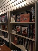 Front view showing the two matching bookshelves filled with various books, highlighting surface scratches and shelf arrangement.