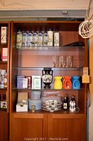 Full shelf setup showing Aromex diffuser oils on top glass shelf, glass candle holders, ceramic candle covers, decorative mirrors, and packaging boxes below.