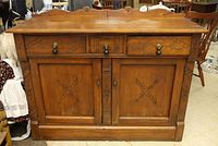 Front view of wooden sideboard showing three drawers and two-door cabinet