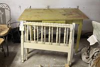Overview of old oak harvest table with drawer, and two small painted headboards in front.