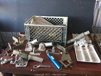 Overview of lot items showing concrete blades, clamps, float parts, and wrench on table
