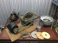 Overall view of machines, two motors, clamps, wheels and accessories arranged on table